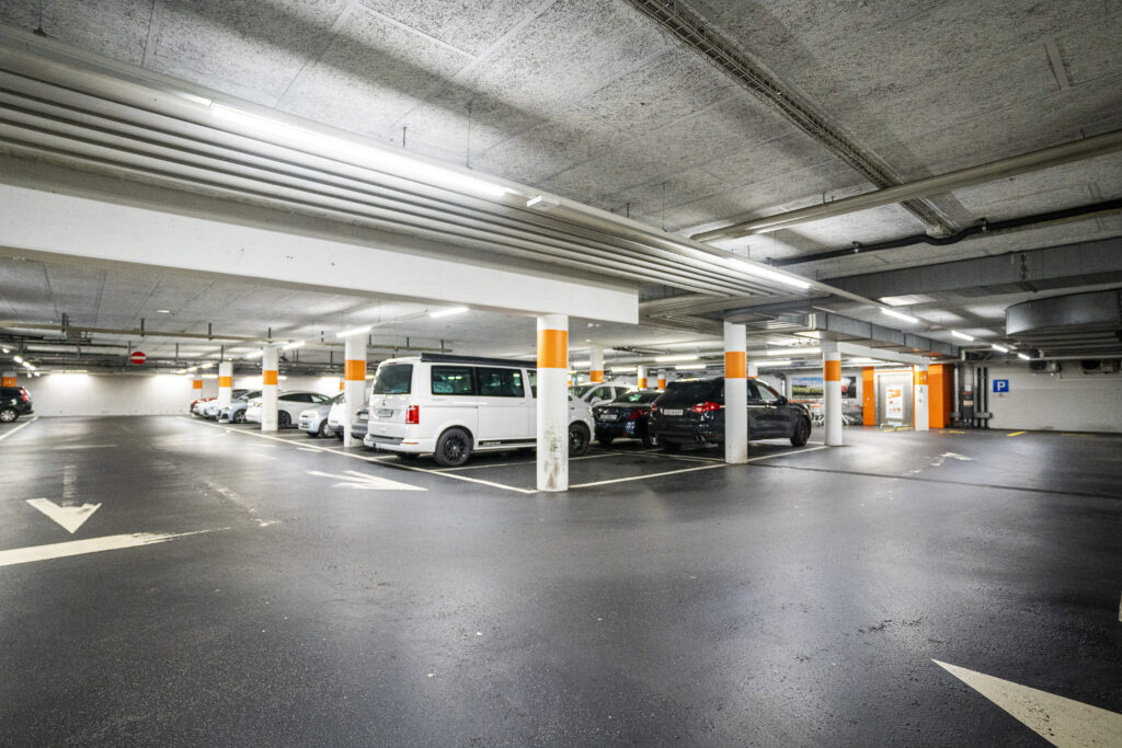 A wide view through the car park level in Zuchwil, showing the driveways and the orange lift shaft