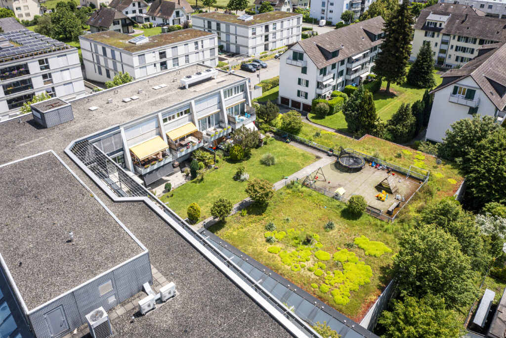 Aerial view of the roof terrace in Zuchwil with awnings and the garden behind it