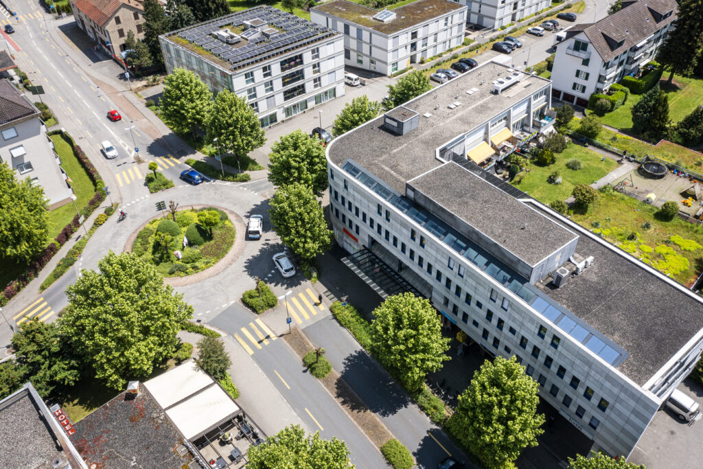 Aerial view of the curved commercial building in Zuchwil, showing the roundabout and the road