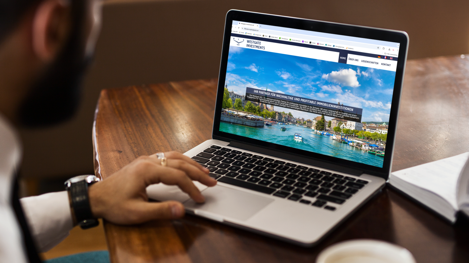 Mann am MacBook mit der Startseite von Westgate Investments und dem Titel zu nachhaltigen Immobilieninvestitionen