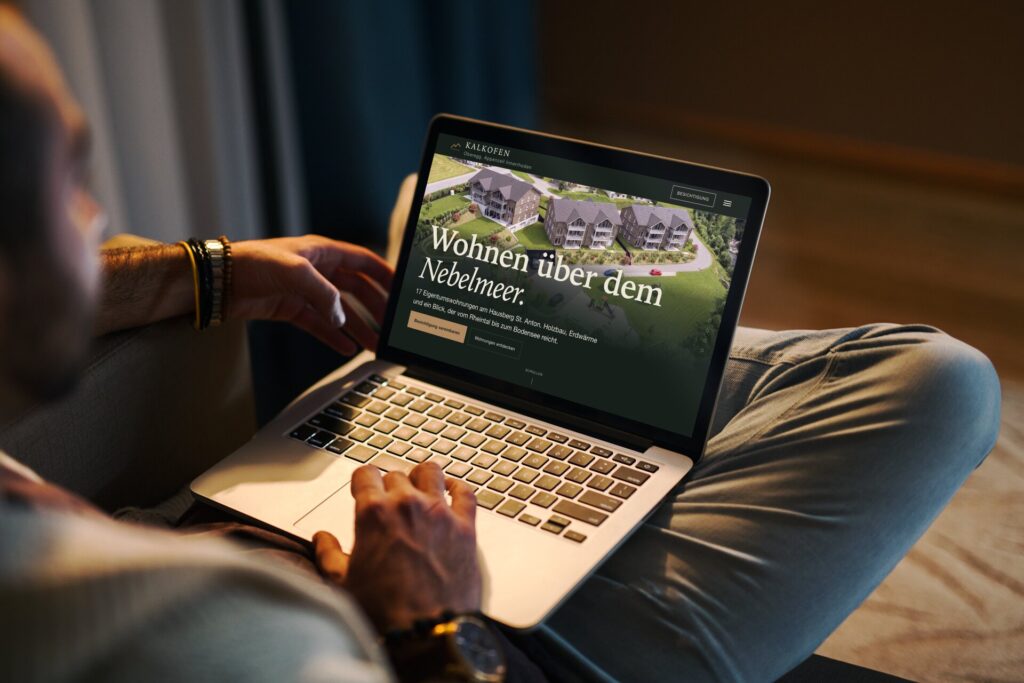 Startseite von kalkofen-oberegg.ch auf einem MacBook: Luftbild der drei Häuser am Hausberg St. Anton